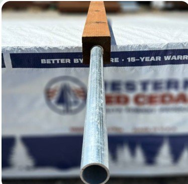 Galvanized pipe running up into a drilled jumbo post